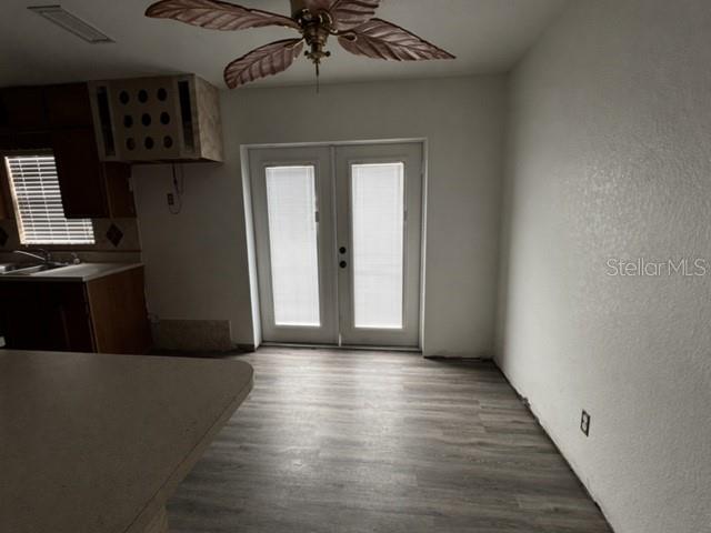 A room with wood-look flooring, a ceiling fan, and glass French doors leading outside — 1129 SW GOLDEN AVENUE, ARCADIA, FL