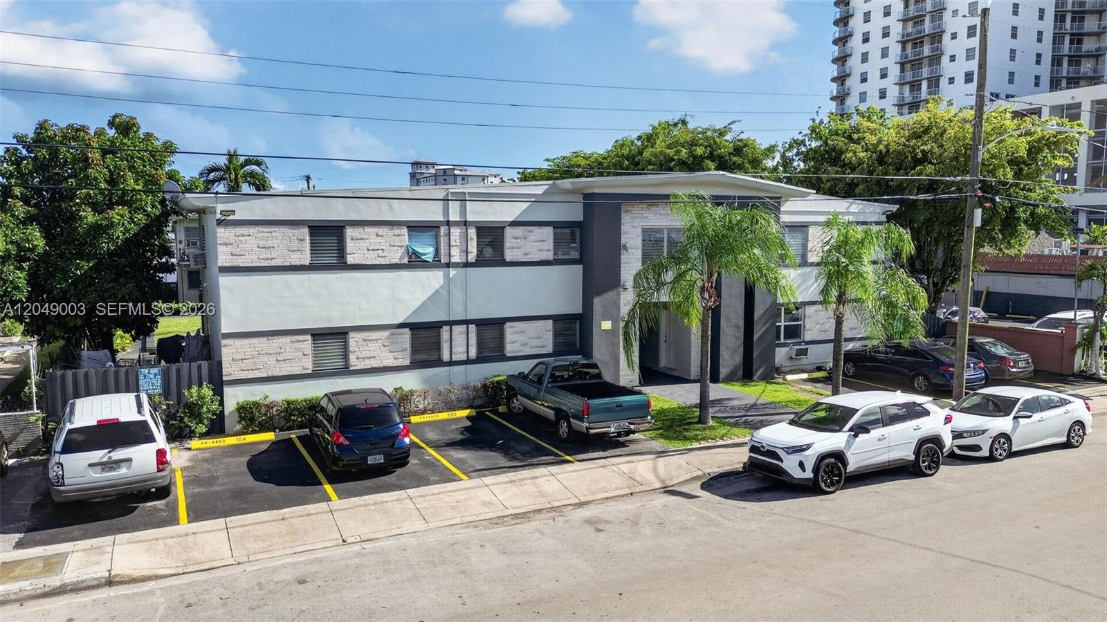 An exterior view of a two-story apartment building with a parking lot in front — 2170 NW Flagler Ter, Miami FL 33125, MIAMI, FL