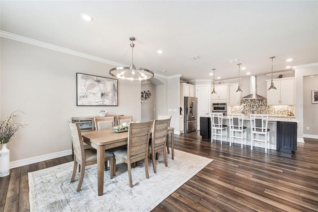 A dining area with a wooden table and chairs sits adjacent to an open kitchen — 6259 SW 93RD TERRACE, OCALA, FL