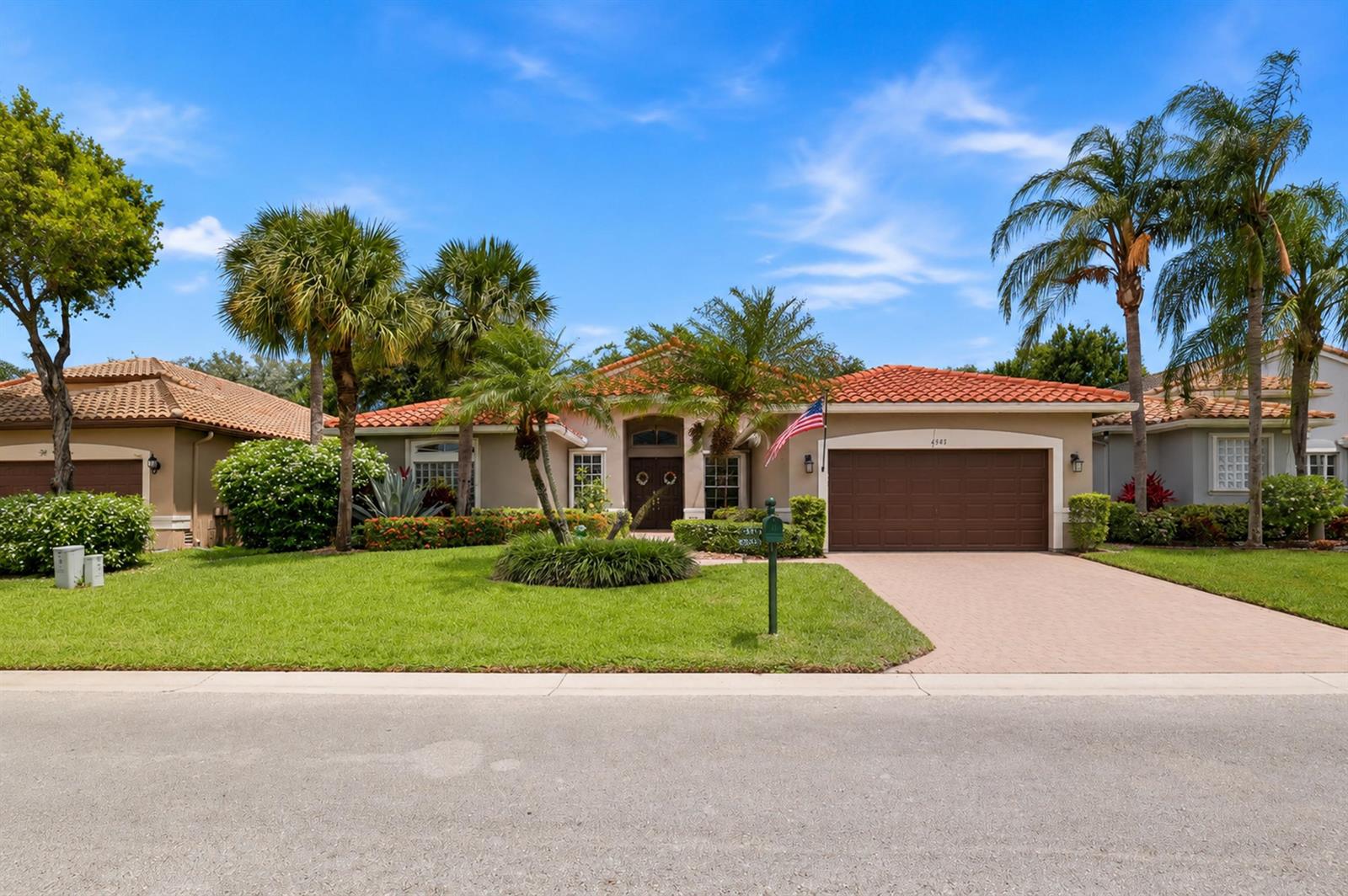 A single-story house with a tile roof, brown garage, and palm trees in the front yard — 6583 Piemonte Drive, Boynton Beach FL 33472, BOYNTON BEACH, FL