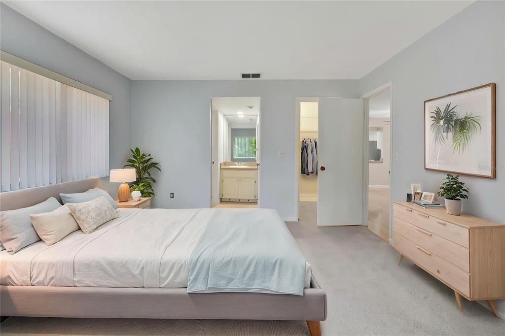 A bedroom with light gray walls, a bed, a dresser, and two doorways leading elsewhere — 63 DOUGLAS STREET UNIT 11, HOMOSASSA, FL