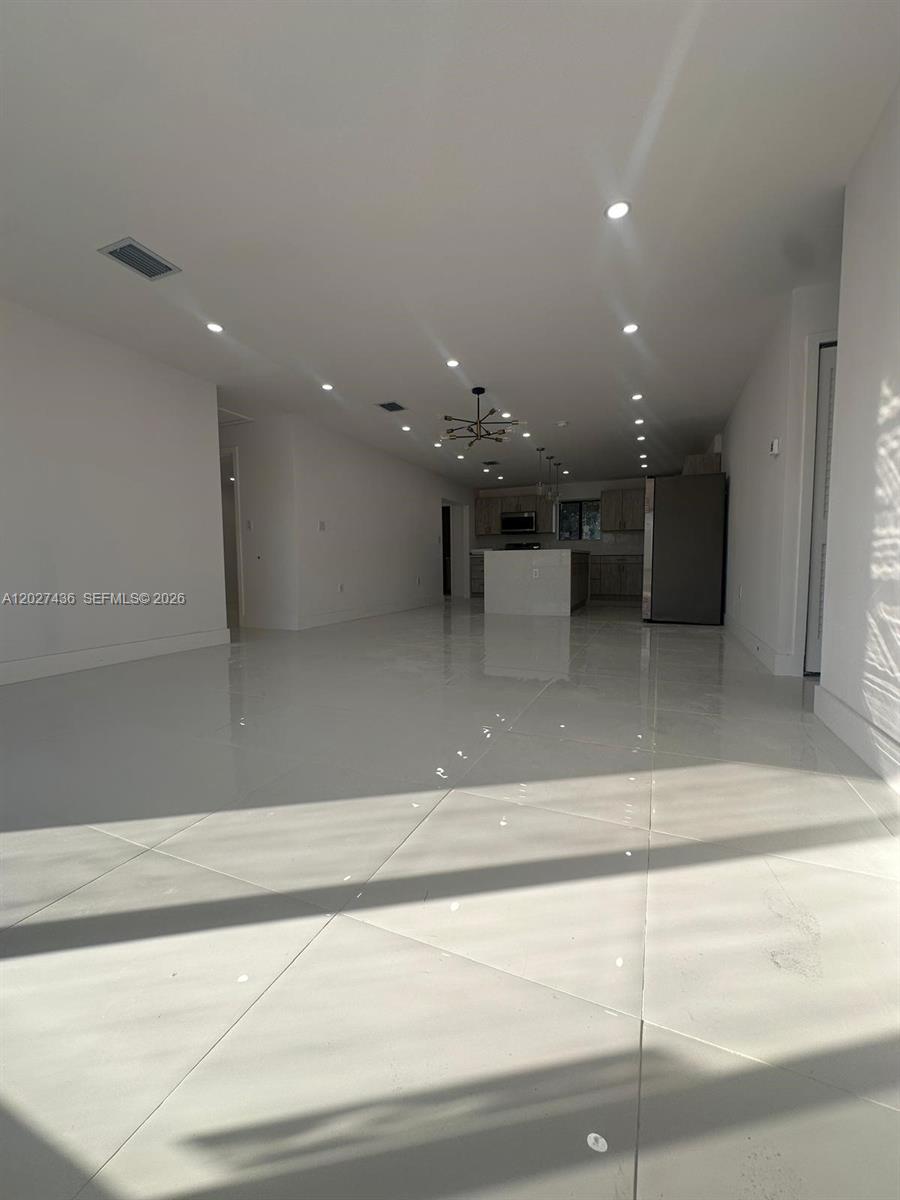 An open-concept living area features white tile flooring, recessed lighting, and a modern kitchen — 2041 NW 190th Ter, Miami Gardens FL 33056, MIAMI GARDENS, FL