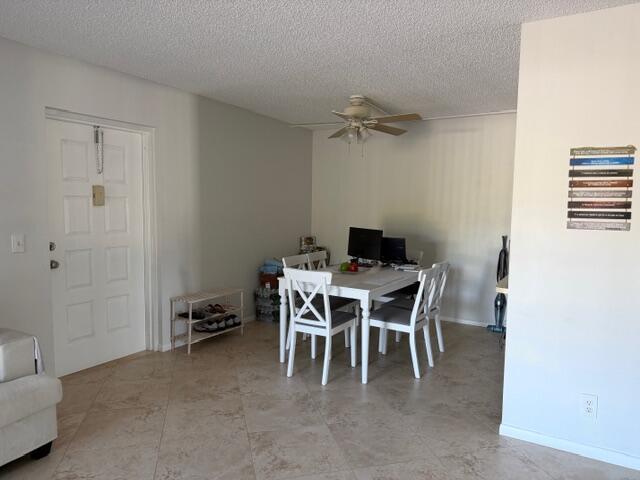 A dining area with a white table, four chairs, and a ceiling fan on tile flooring — 812 Sky Pine Way # D2, FL 33415, FL