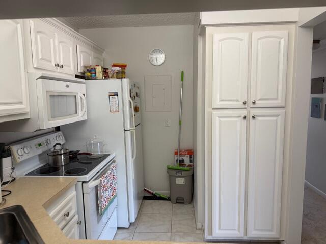 A kitchen features white cabinets, a microwave, a refrigerator, and a tall pantry cabinet — 812 Sky Pine Way # D2, FL 33415, FL