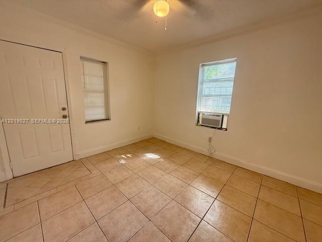 An empty room features white walls, tan tile flooring, a white door, and a window — 3698 William Ave # 5, Miami FL 33133, MIAMI, FL