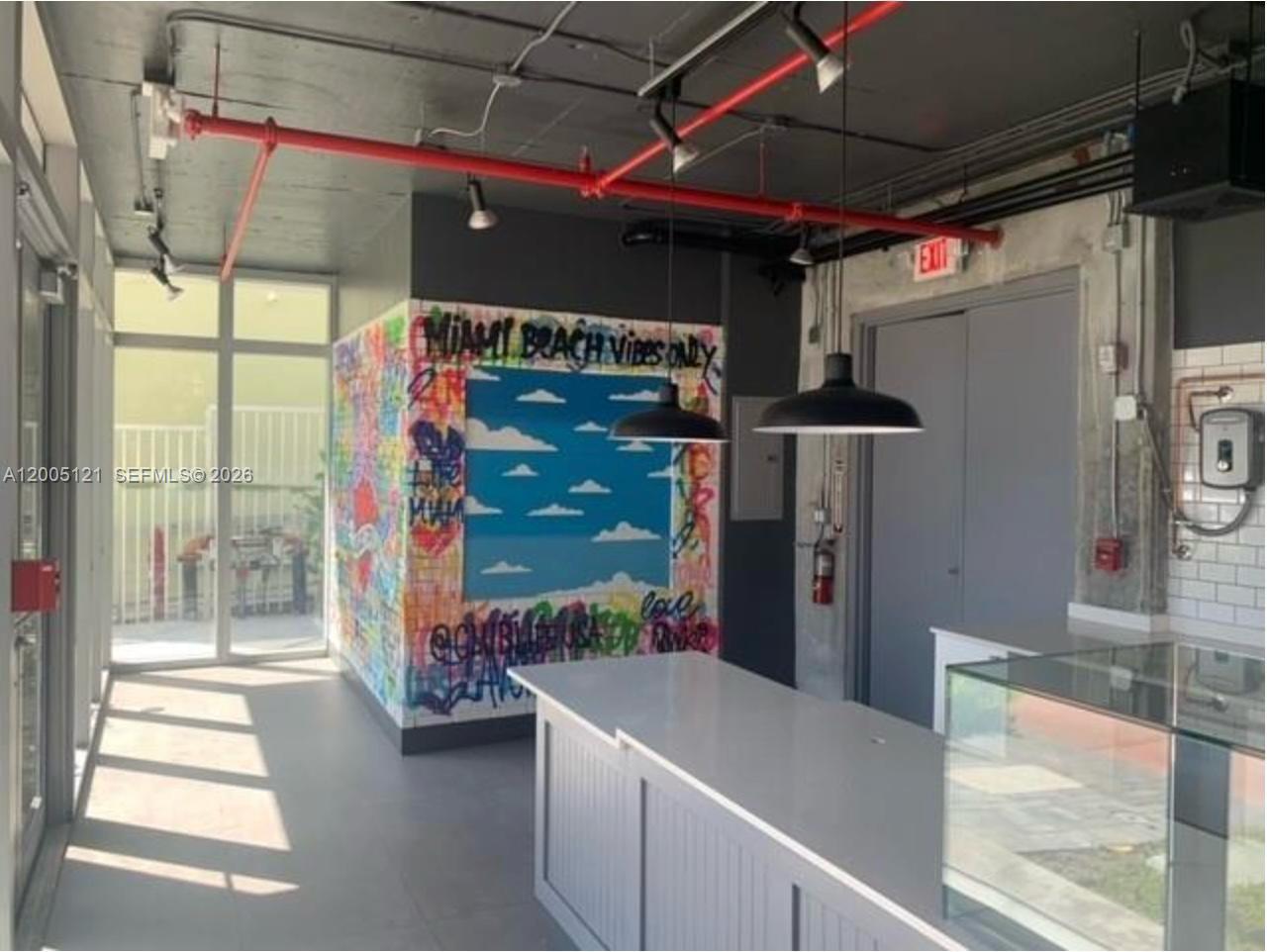 A commercial interior features a graffiti-covered wall, a white counter, and exposed red ceiling pipes — 538 Meridian Ave, Miami Beach FL 33139, MIAMI BEACH, FL