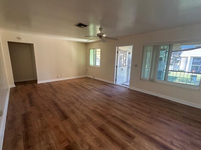 An empty living room features wood-look flooring, a ceiling fan, and a sliding glass door — 3625 La Aires Court # B2, FL 33463, FL