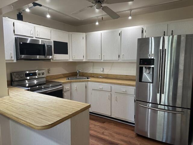A kitchen features white cabinets, stainless steel appliances, and light wood-tone countertops — 3625 La Aires Court # B2, FL 33463, FL