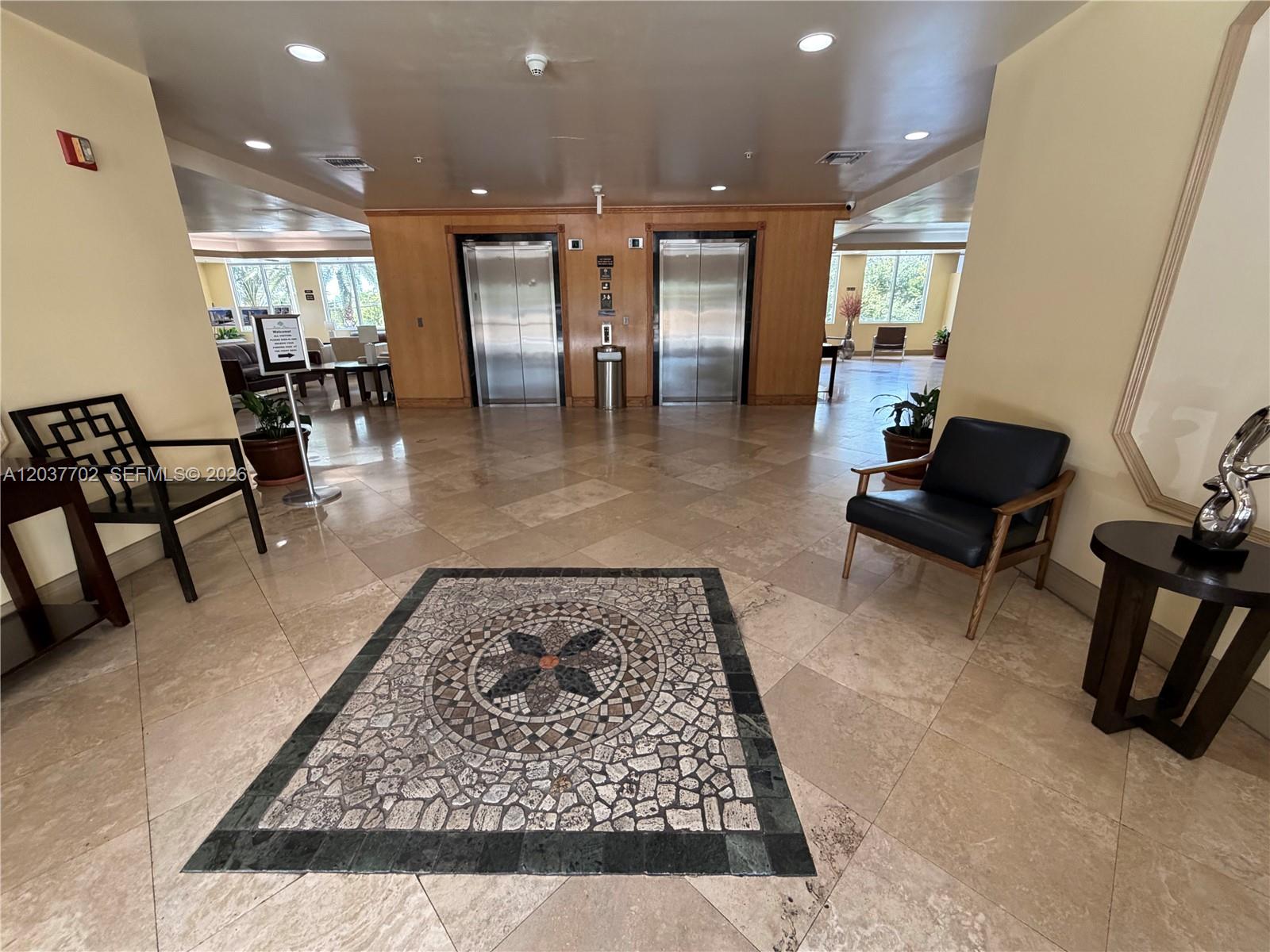 A covered parking garage features a paved stone driveway and several parked vehicles — 3500 Coral Way # 907, Miami FL 33145, MIAMI, FL