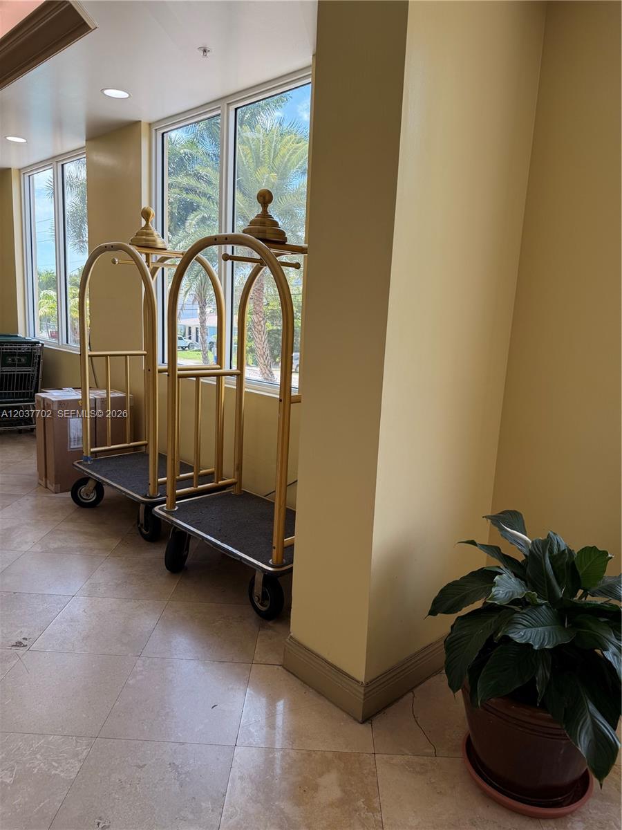 A lobby features two stainless steel elevators, a mosaic floor inlay, and black accent chairs — 3500 Coral Way # 907, Miami FL 33145, MIAMI, FL