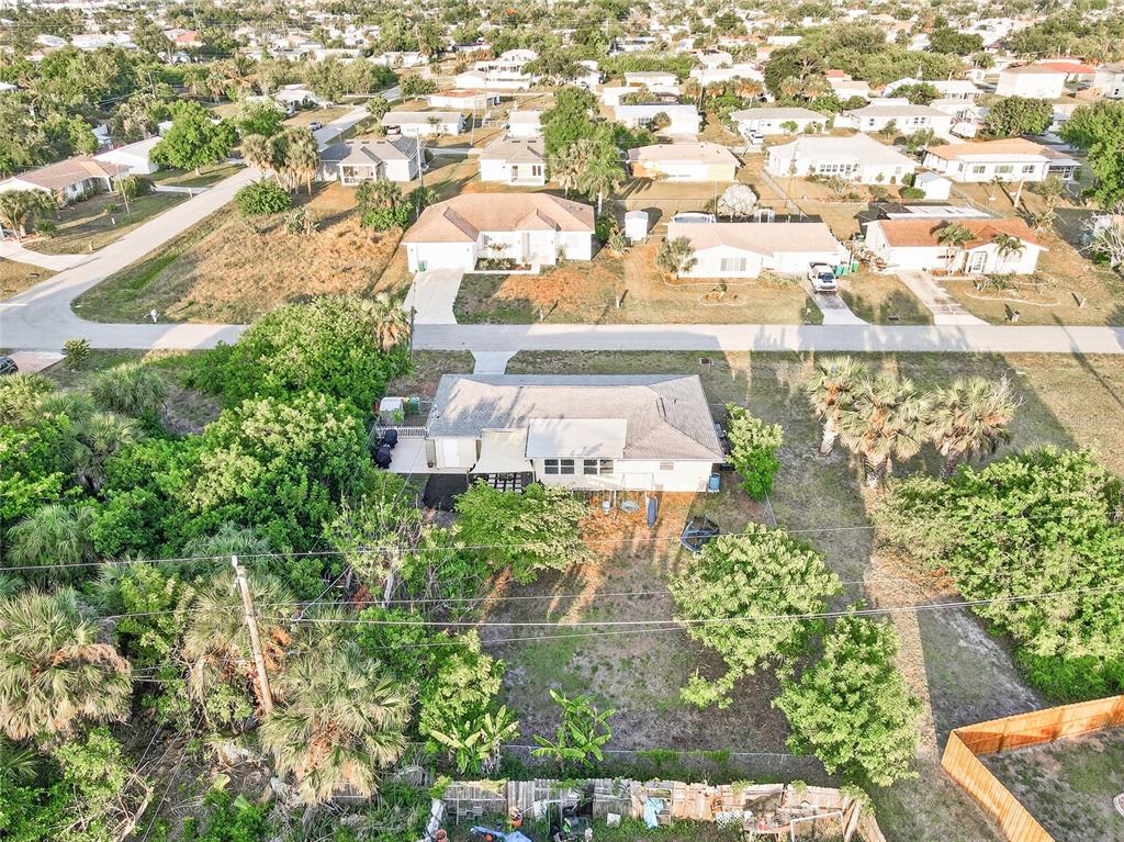 An aerial view shows a single-story house with a large backyard and surrounding neighborhood — 258 READING STREET NW, PORT CHARLOTTE, FL