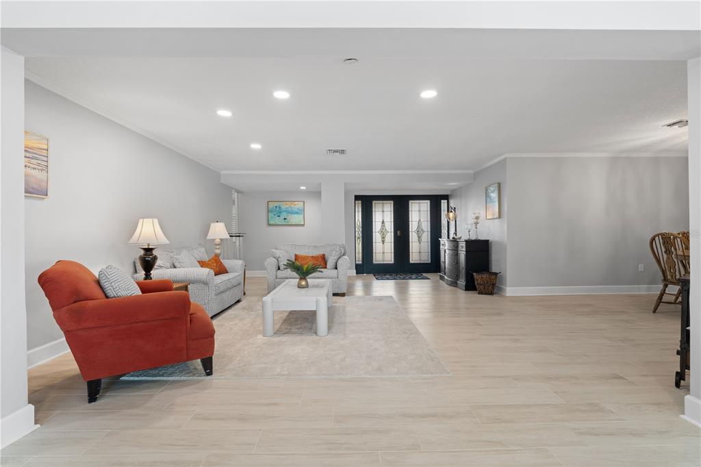 A living room features light tile flooring, a white coffee table, and a dark entryway — 2211 PALM TREE DRIVE, PUNTA GORDA, FL