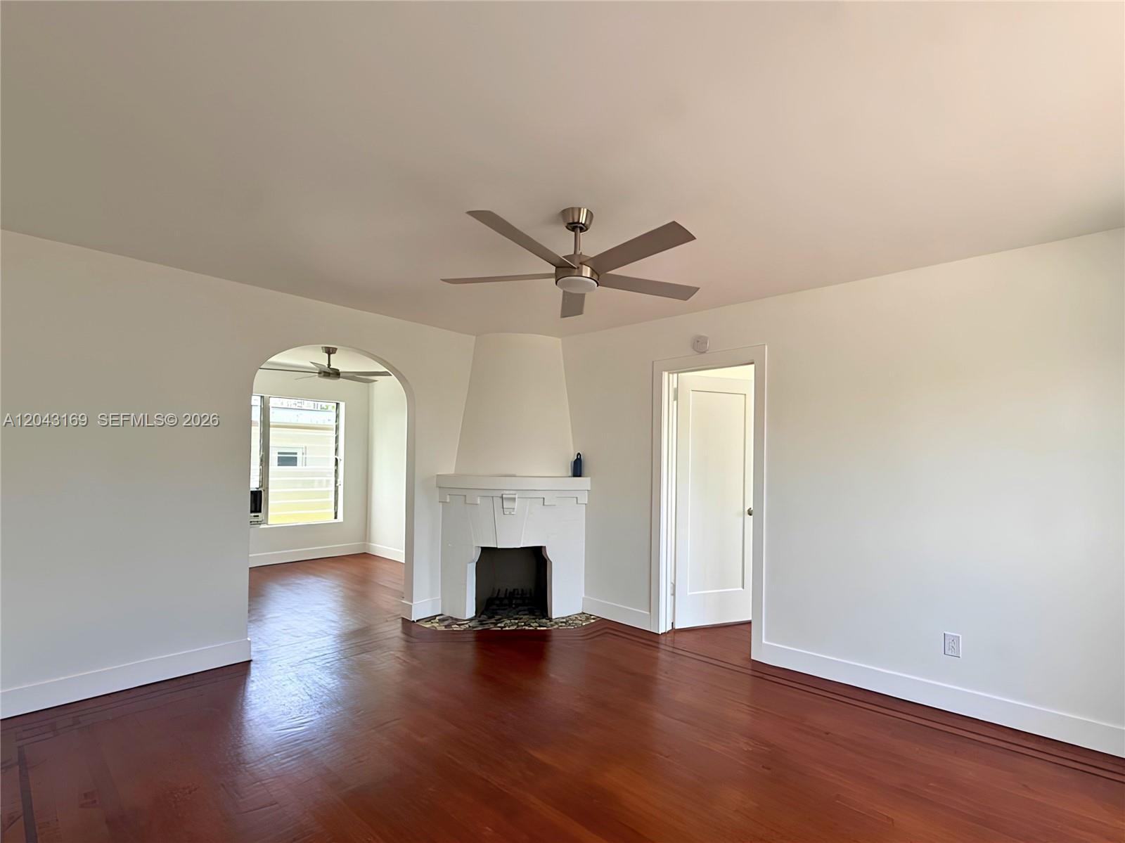 A living room features hardwood floors, a corner fireplace, and an arched entryway — 641 10th St # 7, Miami Beach FL 33139, MIAMI BEACH, FL