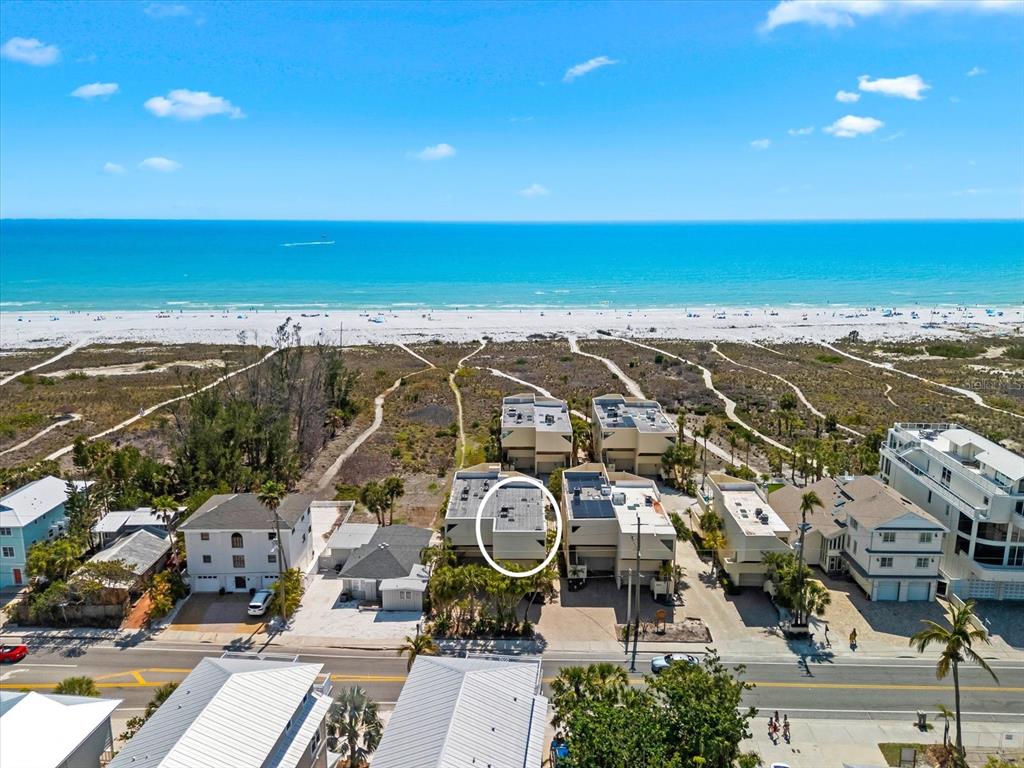 An aerial view shows a beachside property with a circled building and surrounding homes — 548A BEACH ROAD, SARASOTA, FL