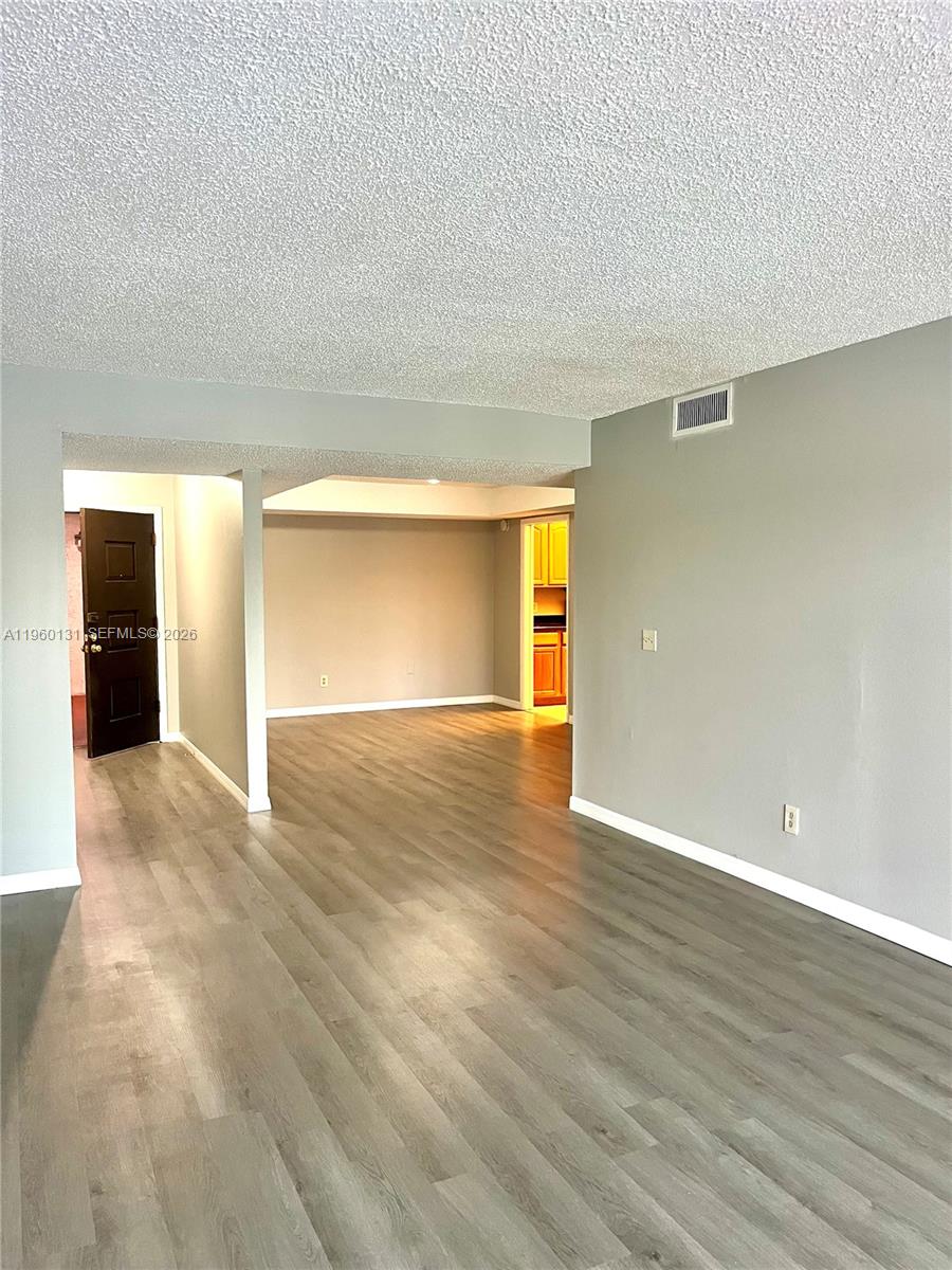 An interior view shows a living area with gray walls and light wood-look flooring — 4575 S Texas Ave # 307, Orlando FL 32839, ORLANDO, FL