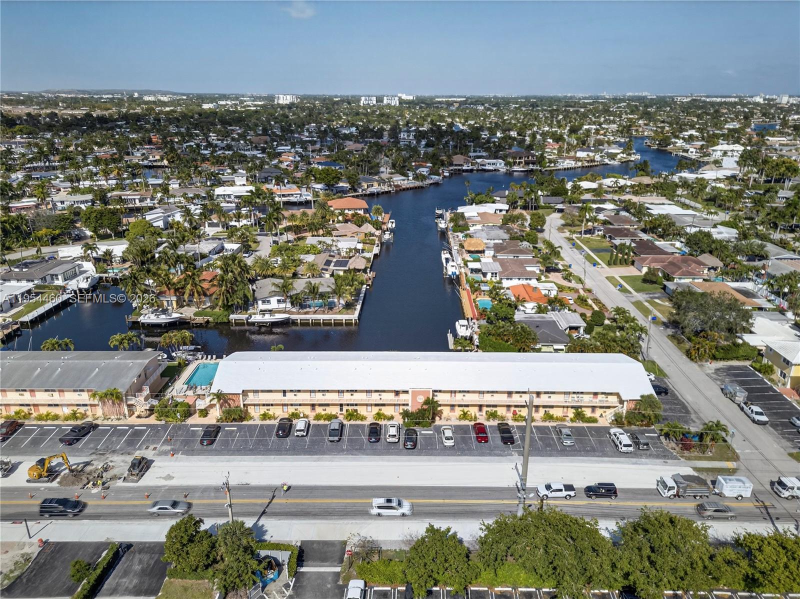 An aerial view shows a multi-story apartment building with a parking lot and canal access — 331 E Mcnab Rd # 226, Pompano Beach FL 33060, POMPANO BEACH, FL