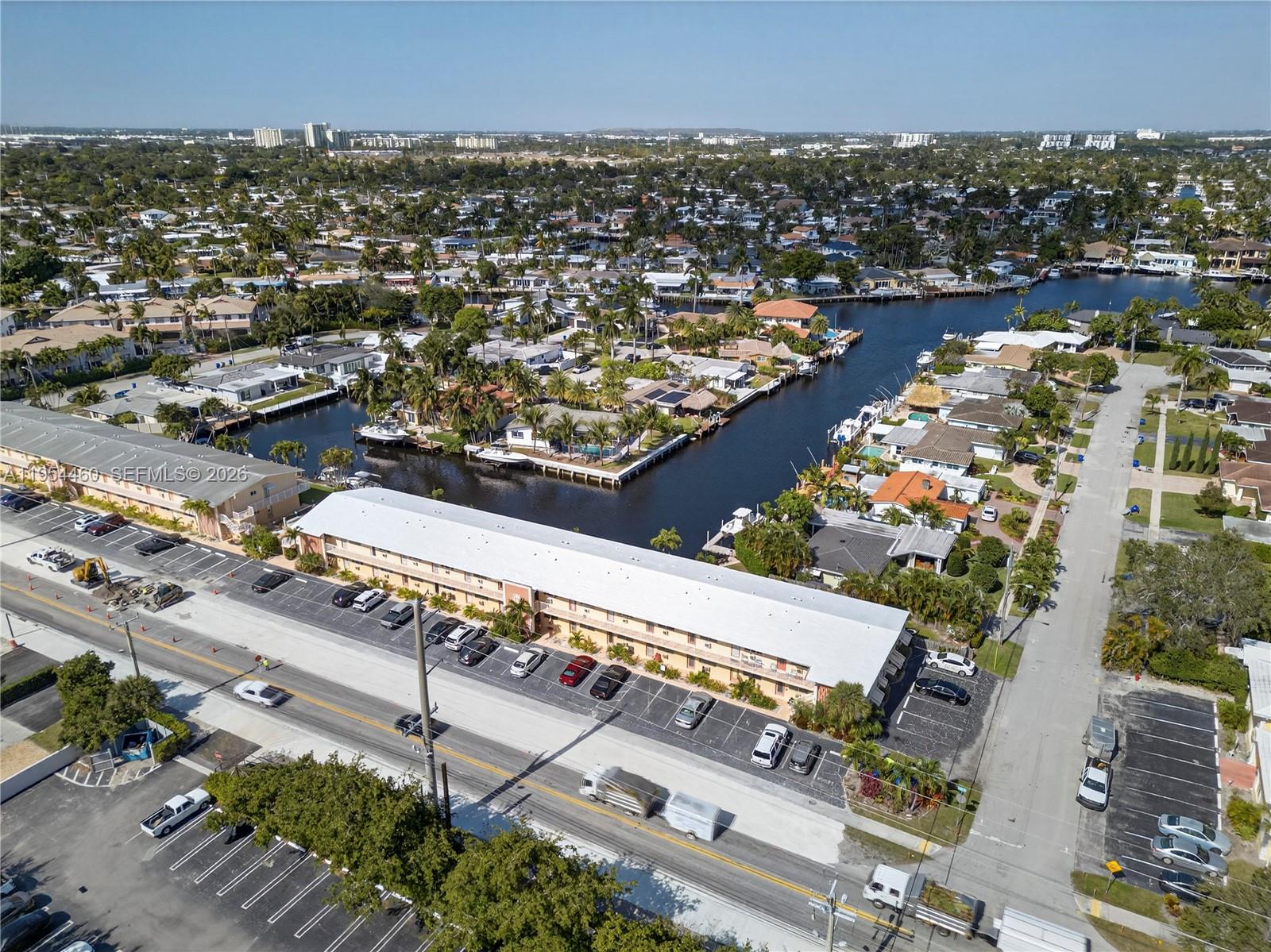 An aerial view shows a long apartment building with a parking lot beside a canal — 331 E Mcnab Rd # 226, Pompano Beach FL 33060, POMPANO BEACH, FL
