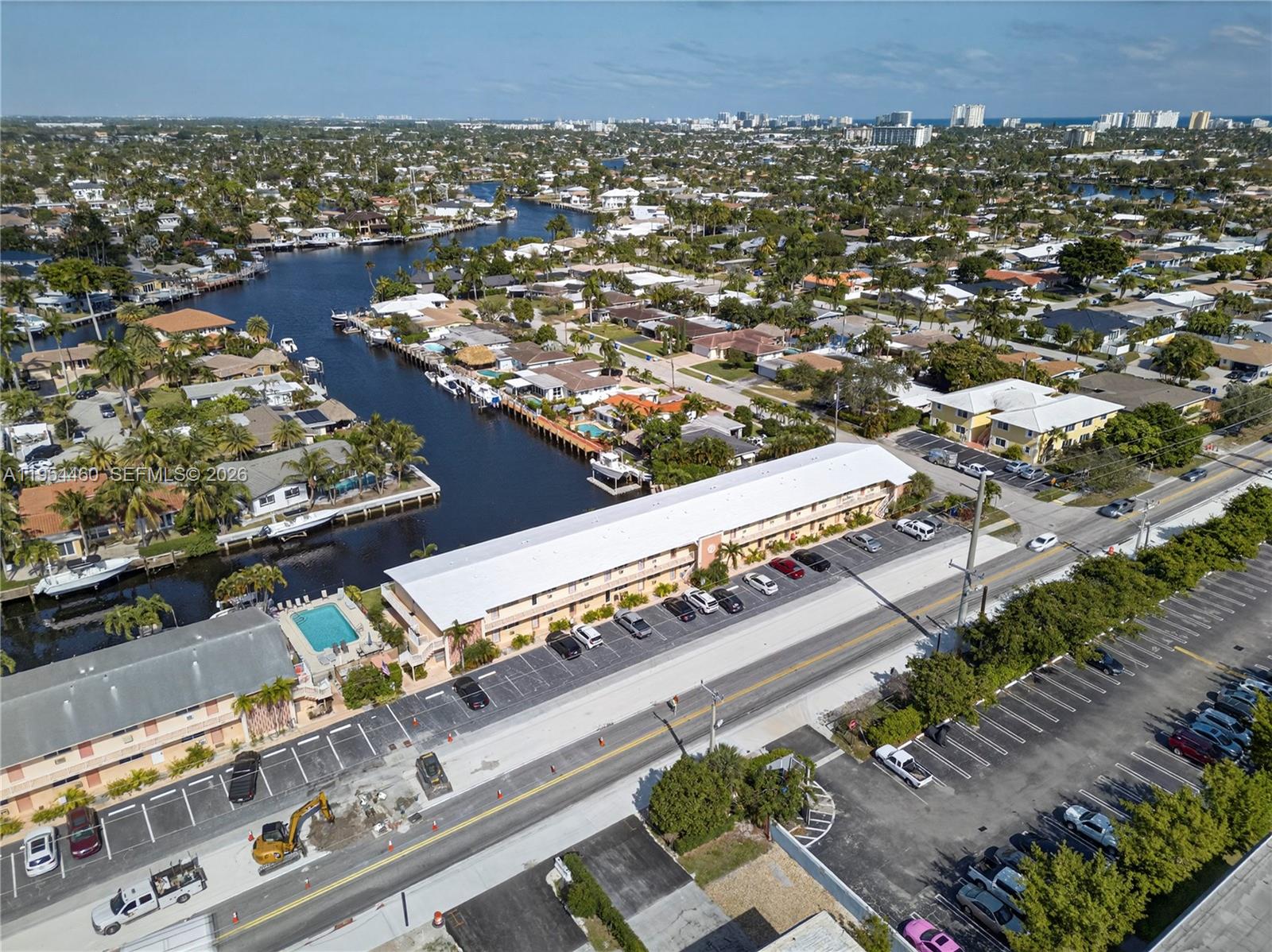 An aerial view shows a long apartment building with a parking lot and canal — 331 E Mcnab Rd # 226, Pompano Beach FL 33060, POMPANO BEACH, FL