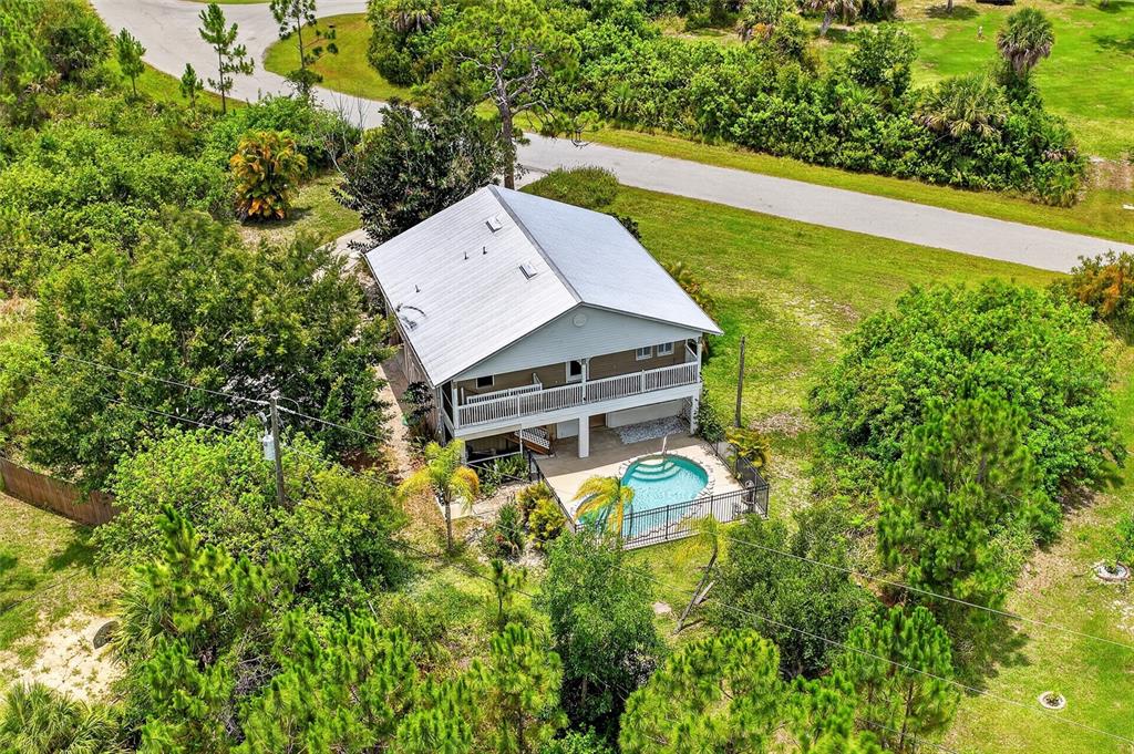 A backyard swimming pool with a stone border and a black metal fence — 5220 ANDERSON ROAD, PORT CHARLOTTE, FL