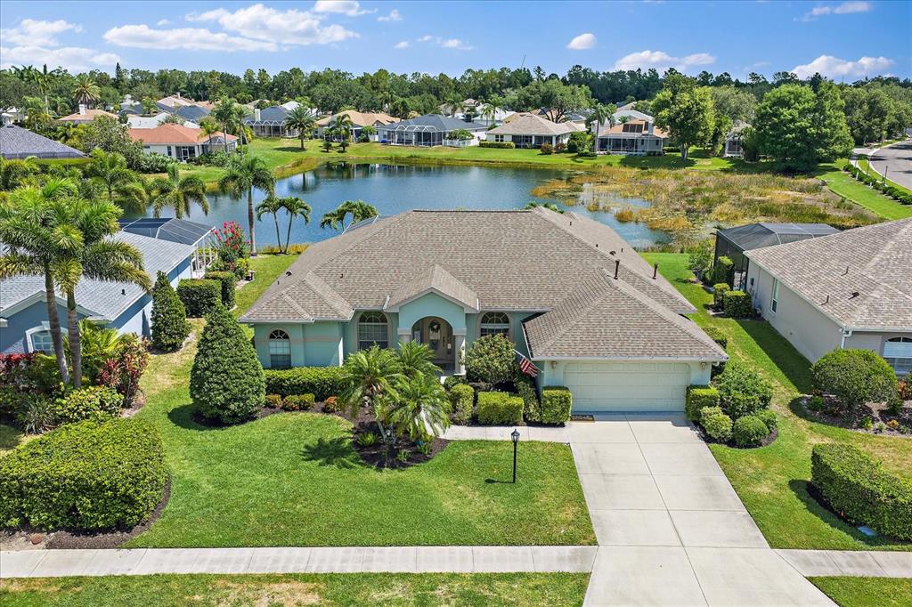 An aerial view of a single-story house with a two-car garage facing a lake — 12111 SUMMER MEADOW DRIVE, LAKEWOOD RANCH, FL