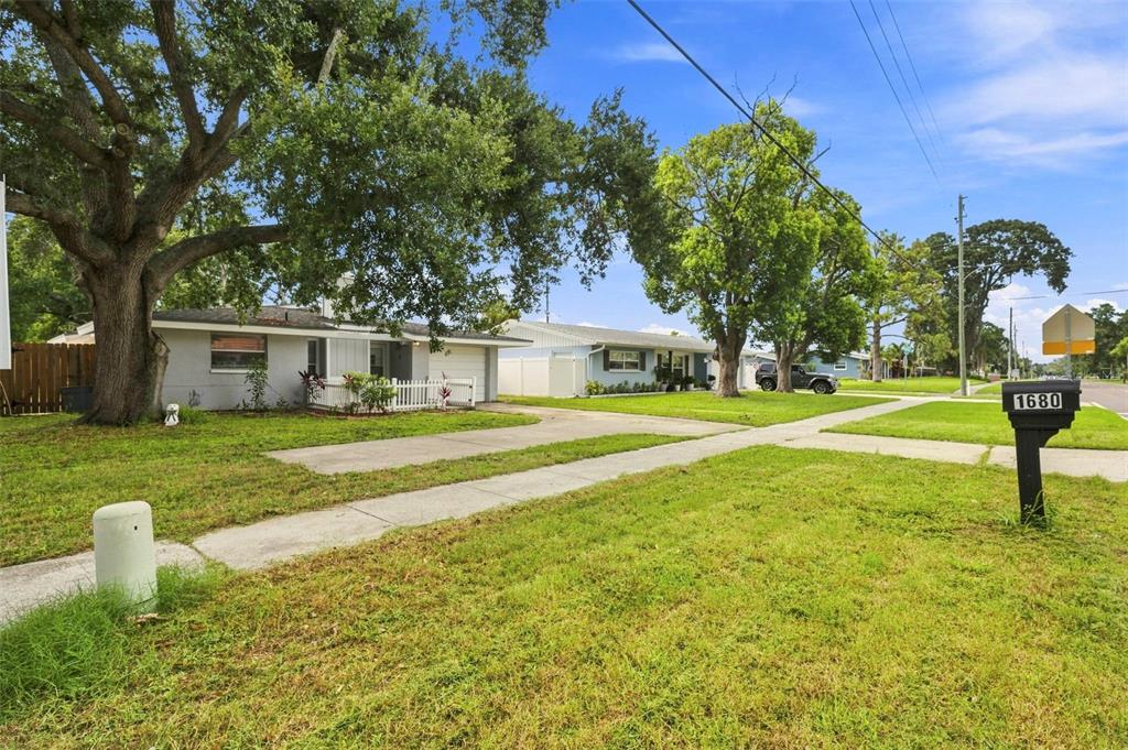 A single-story house with a concrete driveway and a mailbox in the front yard — 1680 PINEHURST ROAD, DUNEDIN, FL