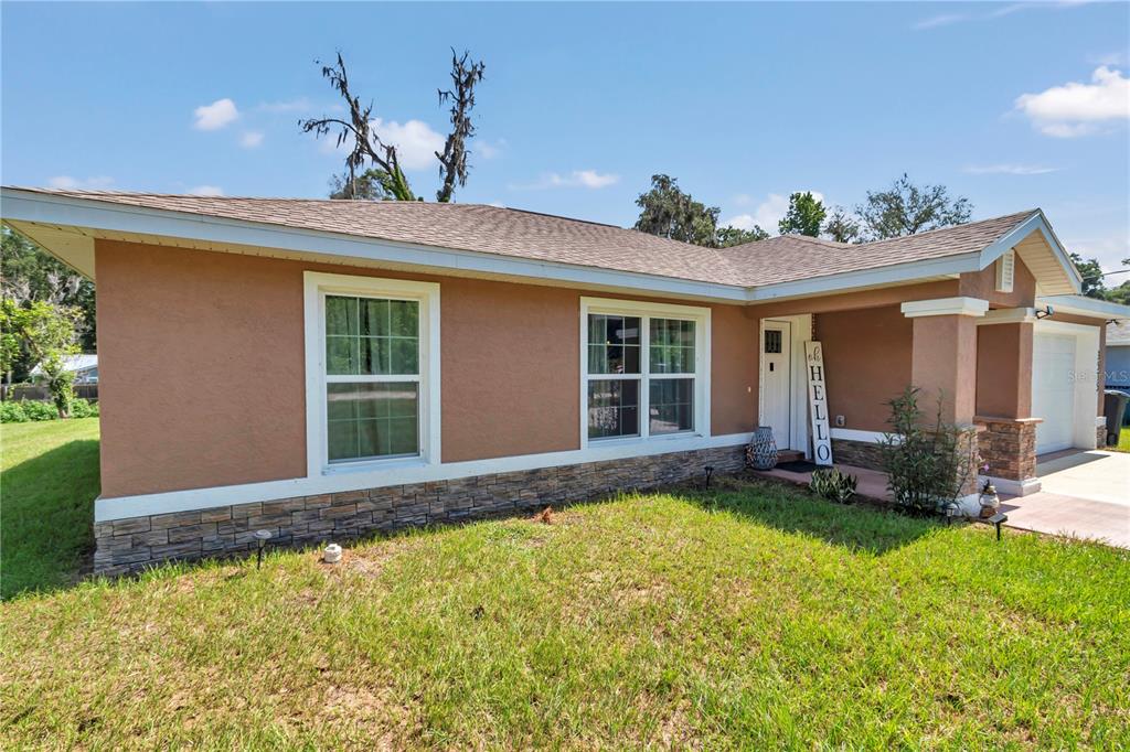 A tan stucco house with stone veneer accents and a covered front porch — 3535 SE 131ST PLACE, BELLEVIEW, FL