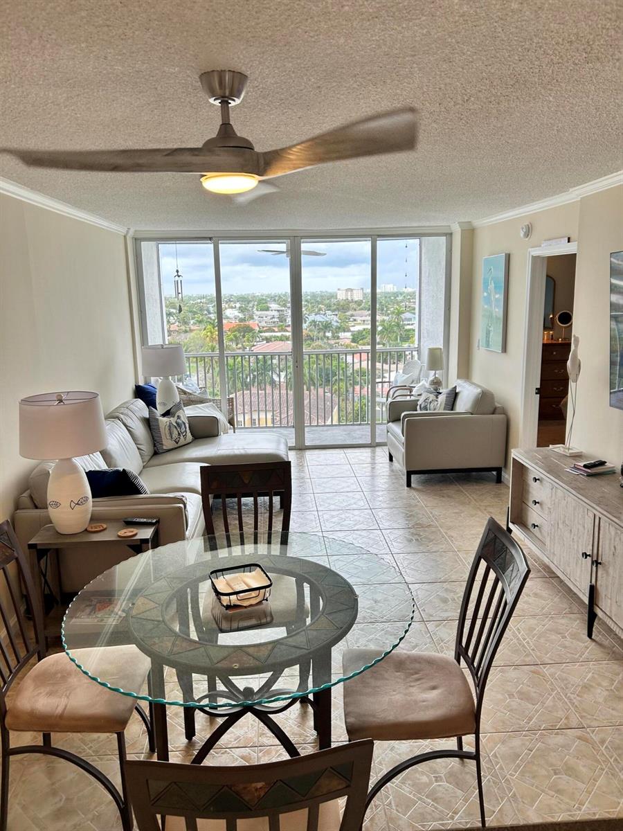A living and dining area with tile floors, a ceiling fan, and a balcony view — 1391 S Ocean Boulevard, Pompano Beach FL 33062, POMPANO BEACH, FL