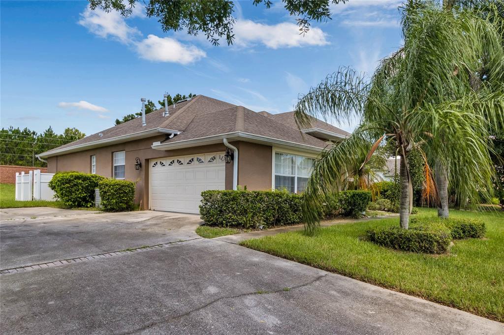 A single-story house with a brown exterior, a white garage door, and a paved driveway — 7973 SEA PEARL CIRCLE, KISSIMMEE, FL