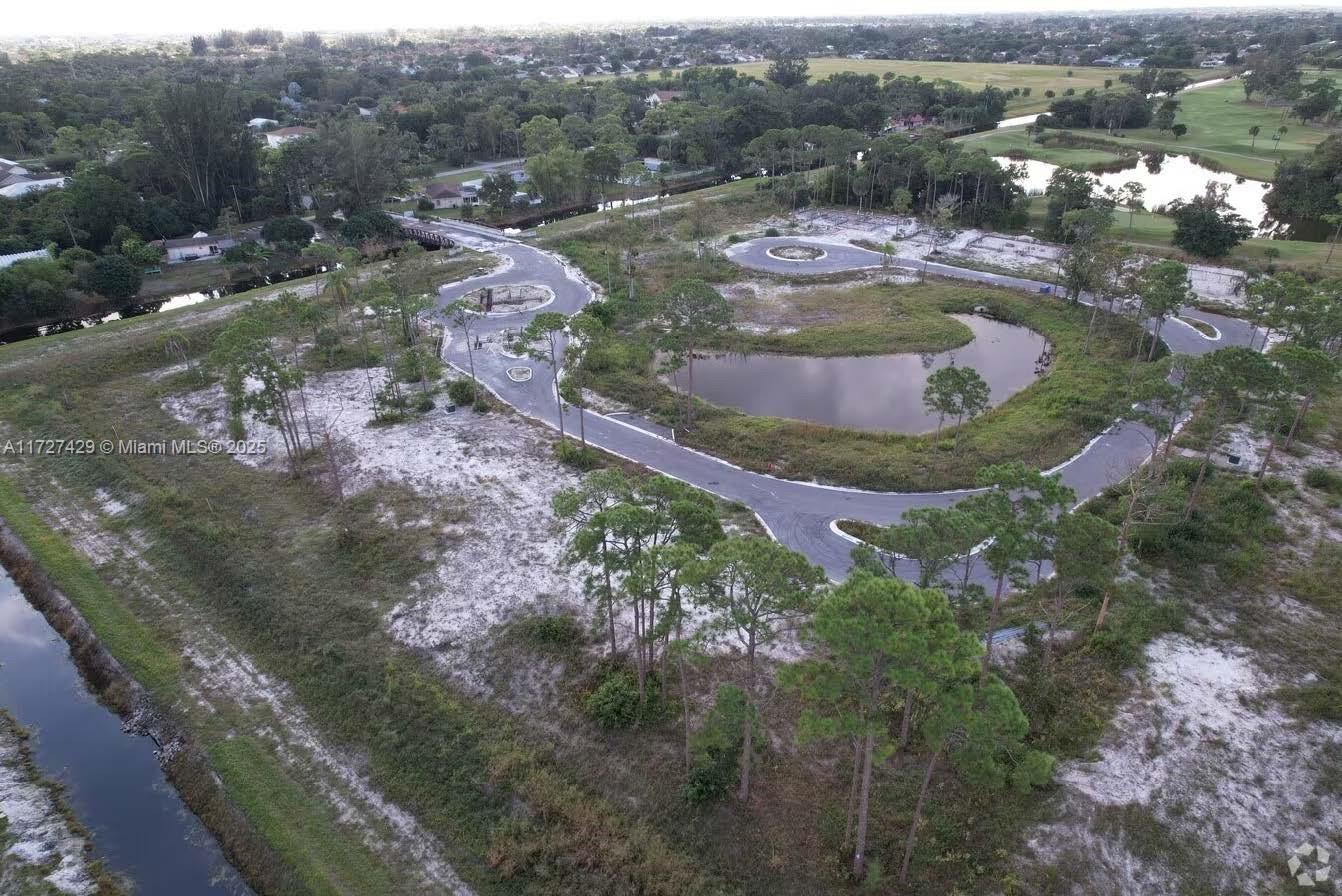 An aerial view shows a partially developed residential lot with paved roads and a pond — 6000 Canal Drive #13, Lake Worth FL 33463, LAKE WORTH, FL