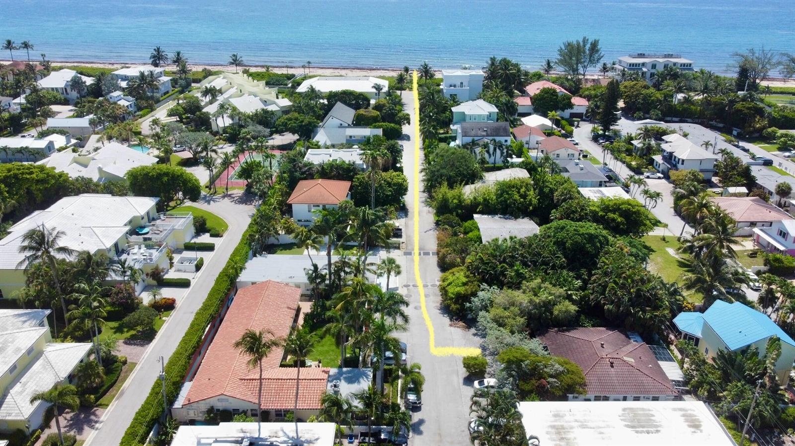 An aerial view shows a residential street leading directly to a sandy beach and ocean — 14 Tropical Drive, Ocean Ridge FL 33435, OCEAN RIDGE, FL