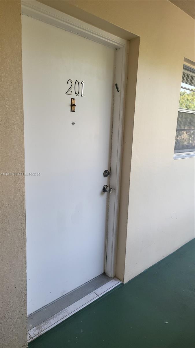 A white exterior door labeled 201 B is set into a beige wall with a window — 1001 NE 14th Ave # 201, Hallandale Beach FL 33009, HALLANDALE BEACH, FL