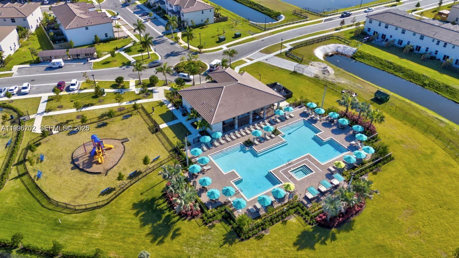 An aerial view shows a community clubhouse with a swimming pool and a playground — 12774 NW 23rd Pl, Miami FL 33167, MIAMI, FL