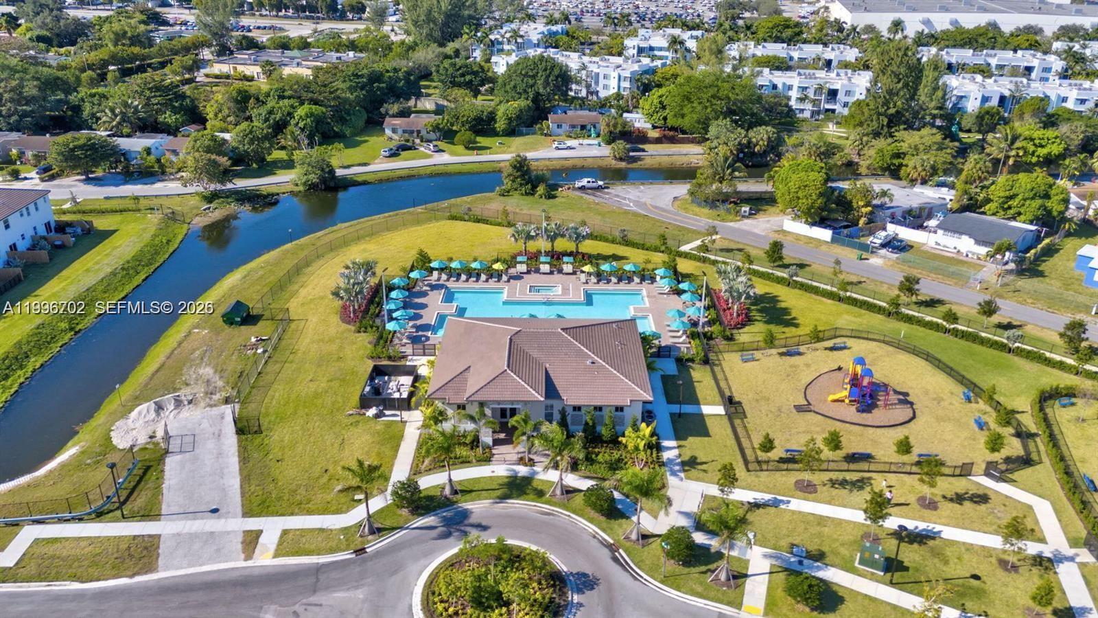 An aerial view shows a community clubhouse with a swimming pool and a playground — 12774 NW 23rd Pl, Miami FL 33167, MIAMI, FL