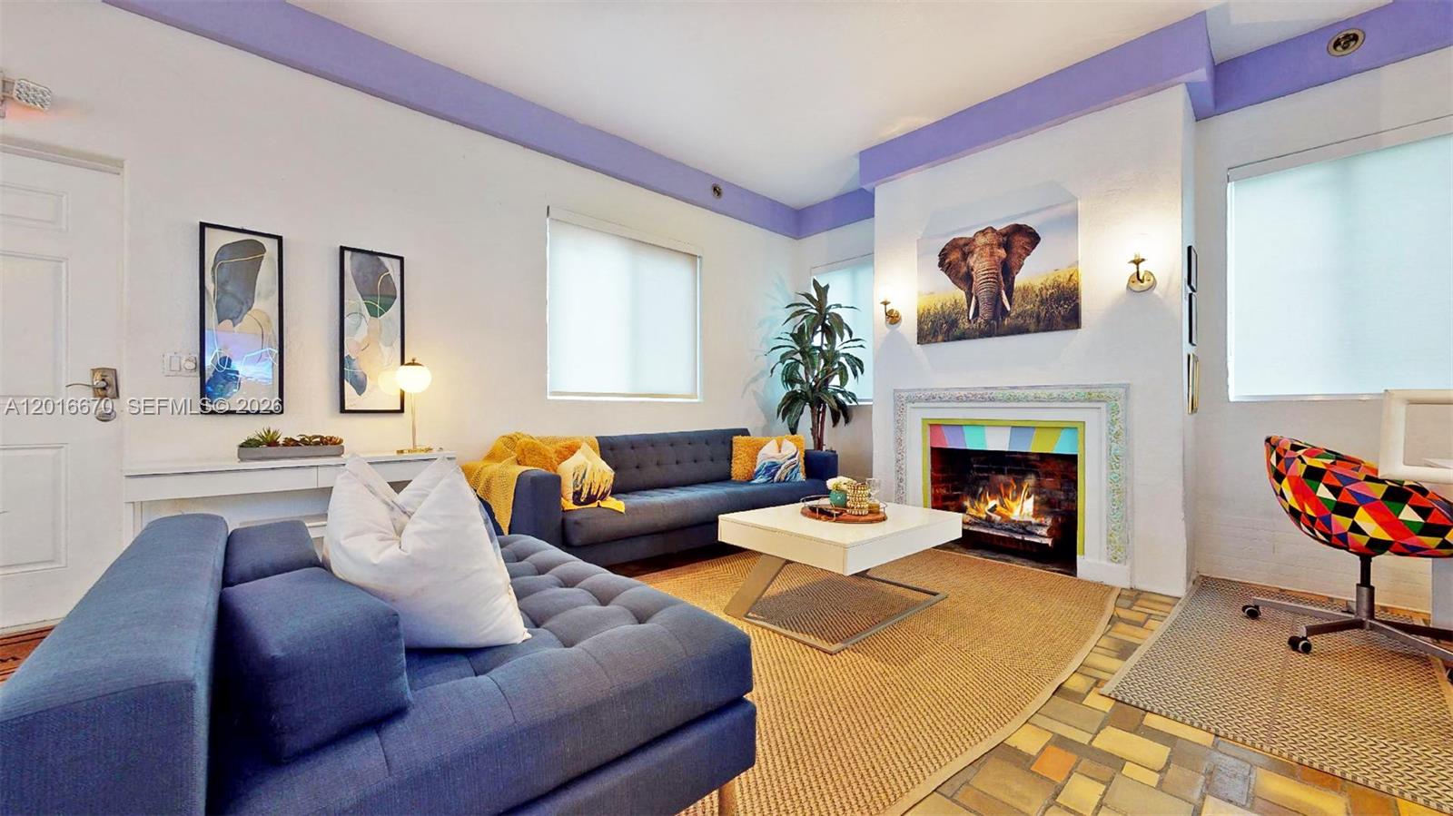 A living room features a blue sofa, a fireplace, and a colorful patterned office chair — 1315 14th St, Miami Beach FL 33139, MIAMI BEACH, FL