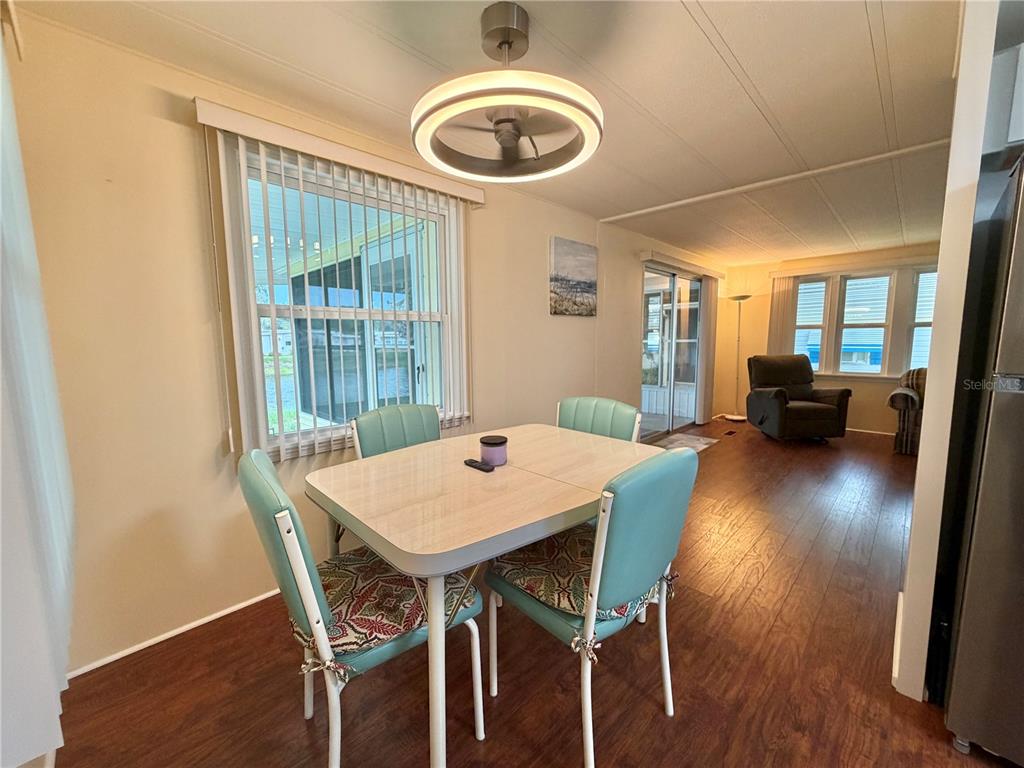 A tiled sunroom features a ceiling fan and large windows overlooking a pond and neighborhood — 119 AUDUBON DRIVE, LEESBURG, FL