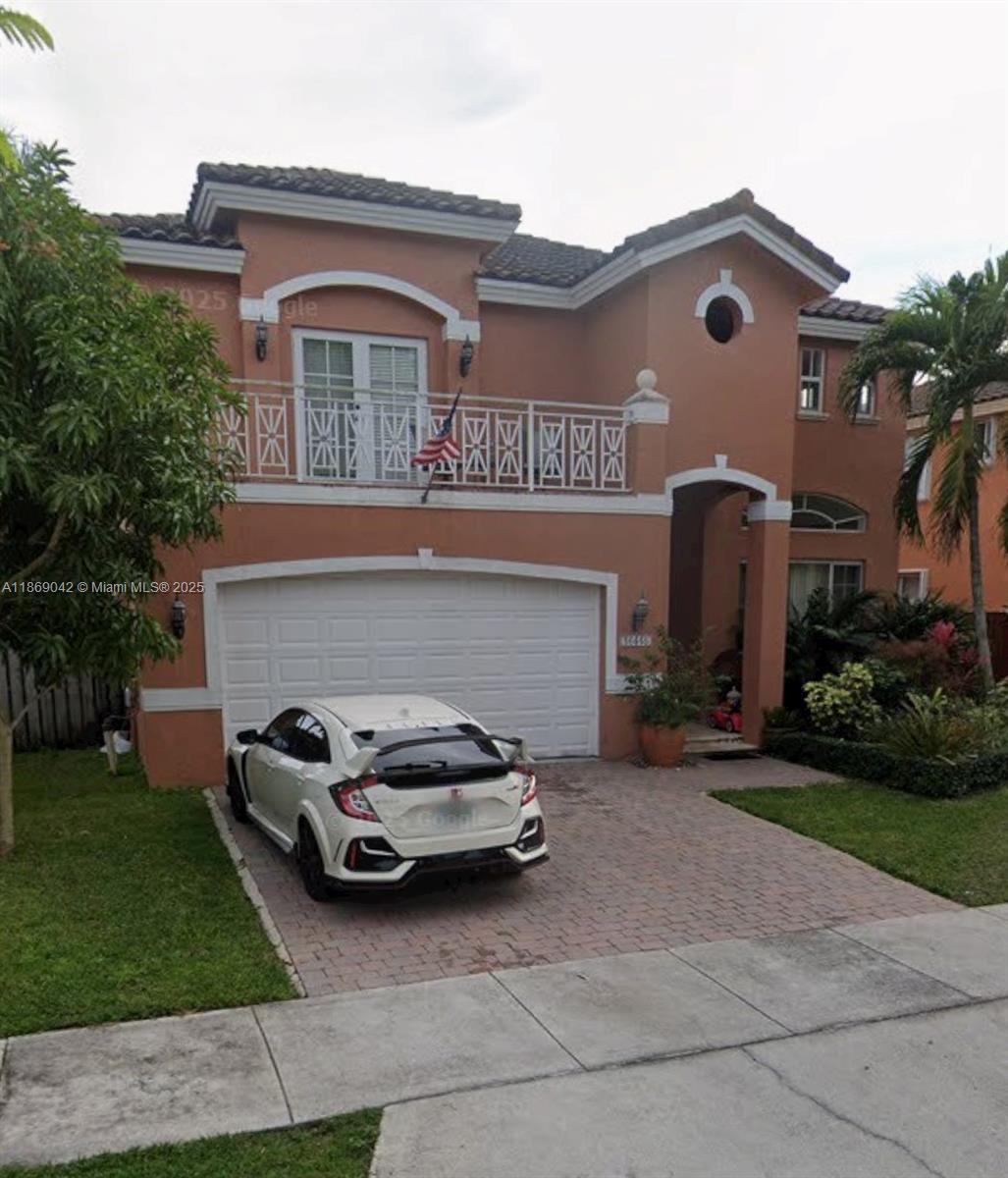 A two-story stucco house with a white garage door and a balcony above it — 16448 SW 67th Ter, Miami FL 33193, MIAMI, FL