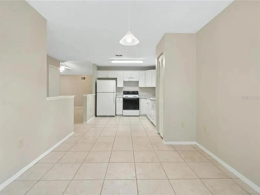 A kitchen with white cabinets, white appliances, and light-colored tile flooring — 1600 CIMARRON HILLS DRIVE, APOPKA, FL
