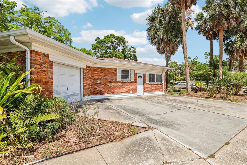 A single-story brick house features a garage, a white front door, and a concrete driveway — 215 S WEST SHORE BOULEVARD, TAMPA, FL