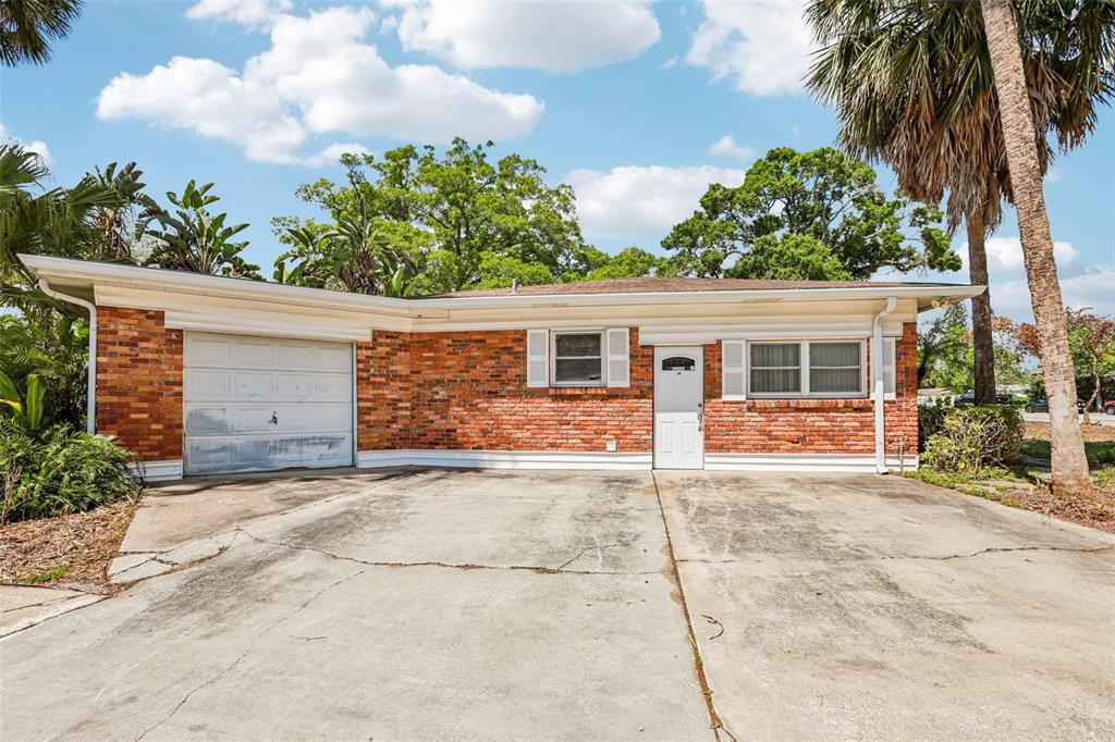 A single-story brick house with a white garage door and a concrete driveway — 215 S WEST SHORE BOULEVARD, TAMPA, FL