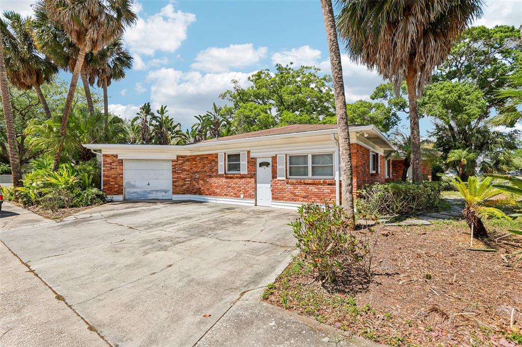 A single-story brick house with a concrete driveway and palm trees in the front yard — 215 S WEST SHORE BOULEVARD, TAMPA, FL
