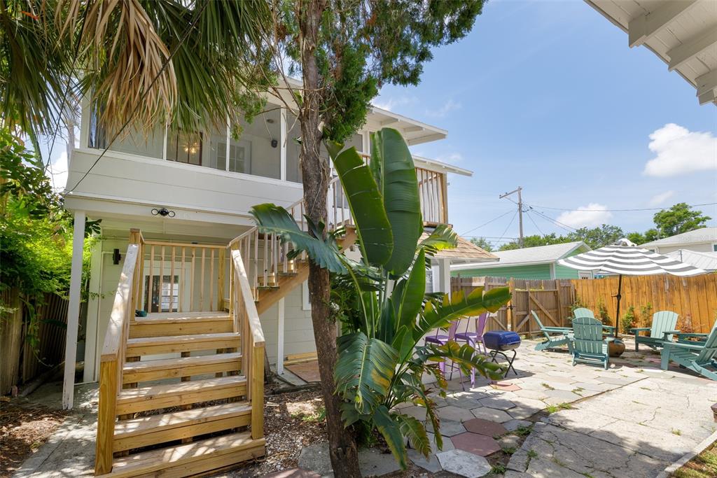A two-story house with a wooden staircase leading to a screened porch and a patio — 618 N 7TH AVENUE UNIT B, ST PETERSBURG, FL
