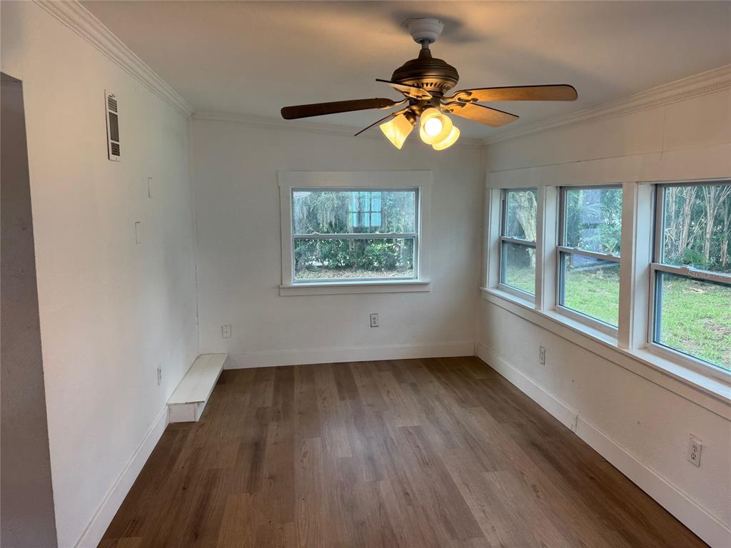 A sunroom with white walls, wood-look flooring, a ceiling fan, and multiple windows — 2121 GREENWAY DRIVE, WINTER HAVEN, FL