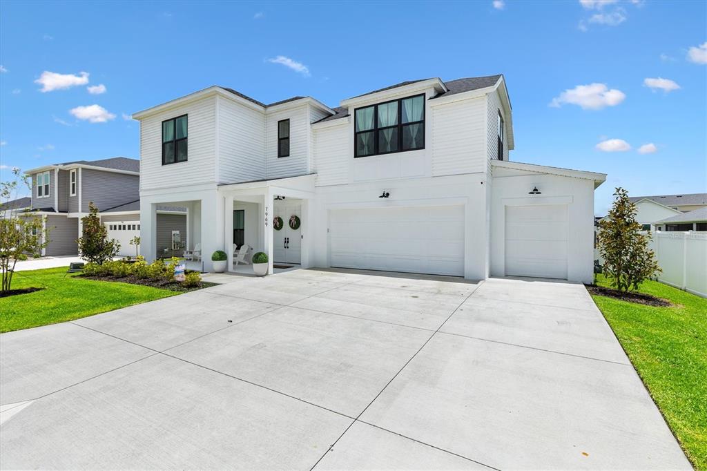 A two-story white house features a concrete driveway, a two-car garage, and a covered porch — 7969 BYERS ST, MIDDLETON, FL