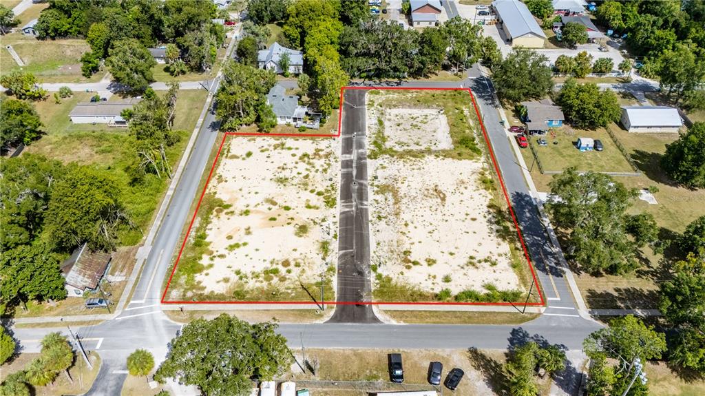 An aerial view shows a vacant, rectangular lot divided by a paved road — 000 SW 1ST STREET, NEWBERRY, FL