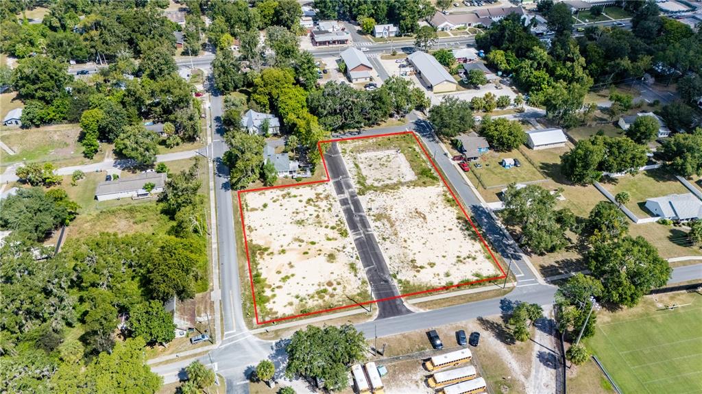An aerial view shows a vacant, rectangular lot divided by a paved road — 000 SW 1ST STREET, NEWBERRY, FL