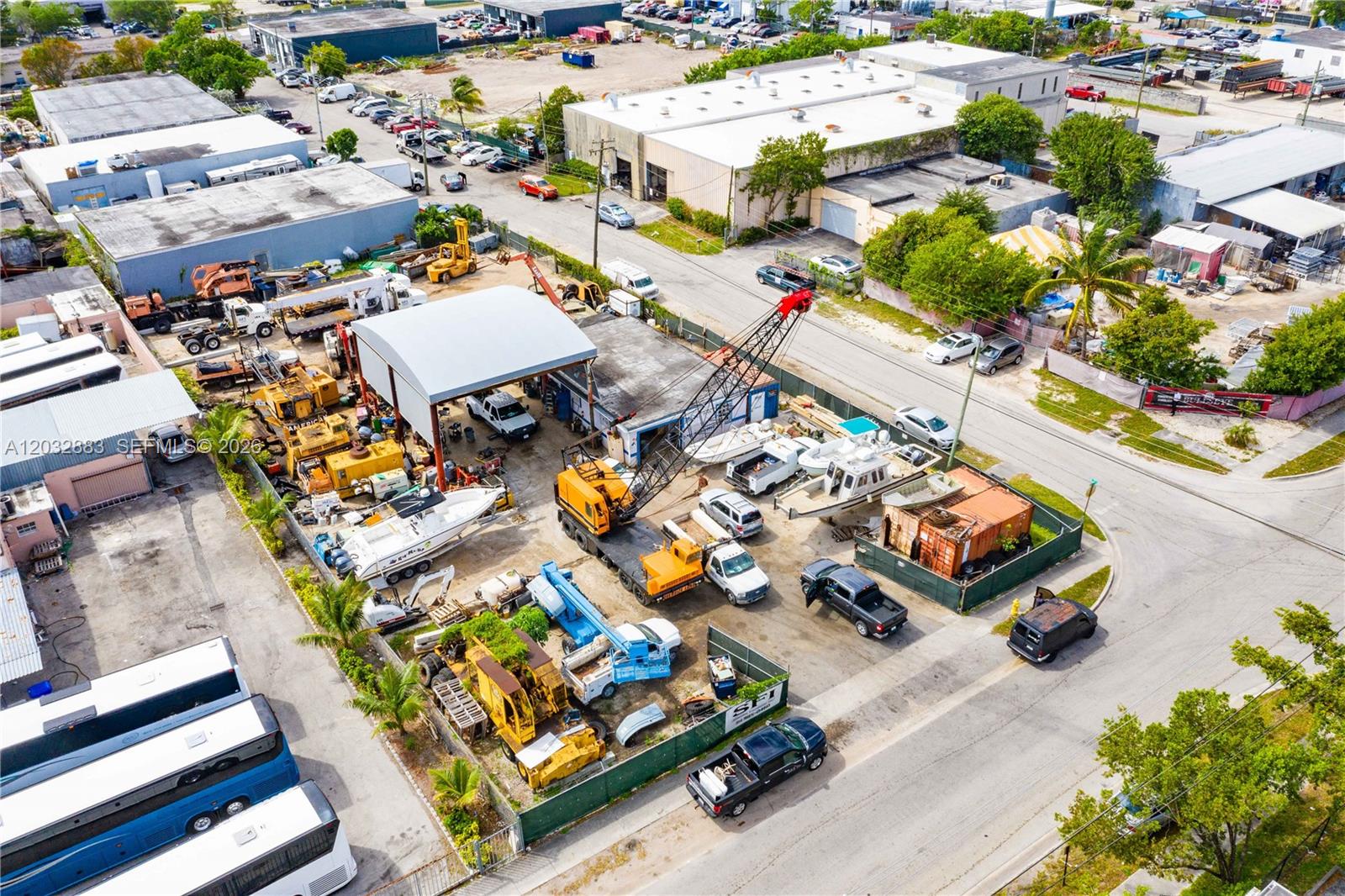 An aerial view shows a fenced industrial lot containing a crane, boats, and vehicles — 2301 SW 57th Ave, West Park FL 33023, WEST PARK, FL