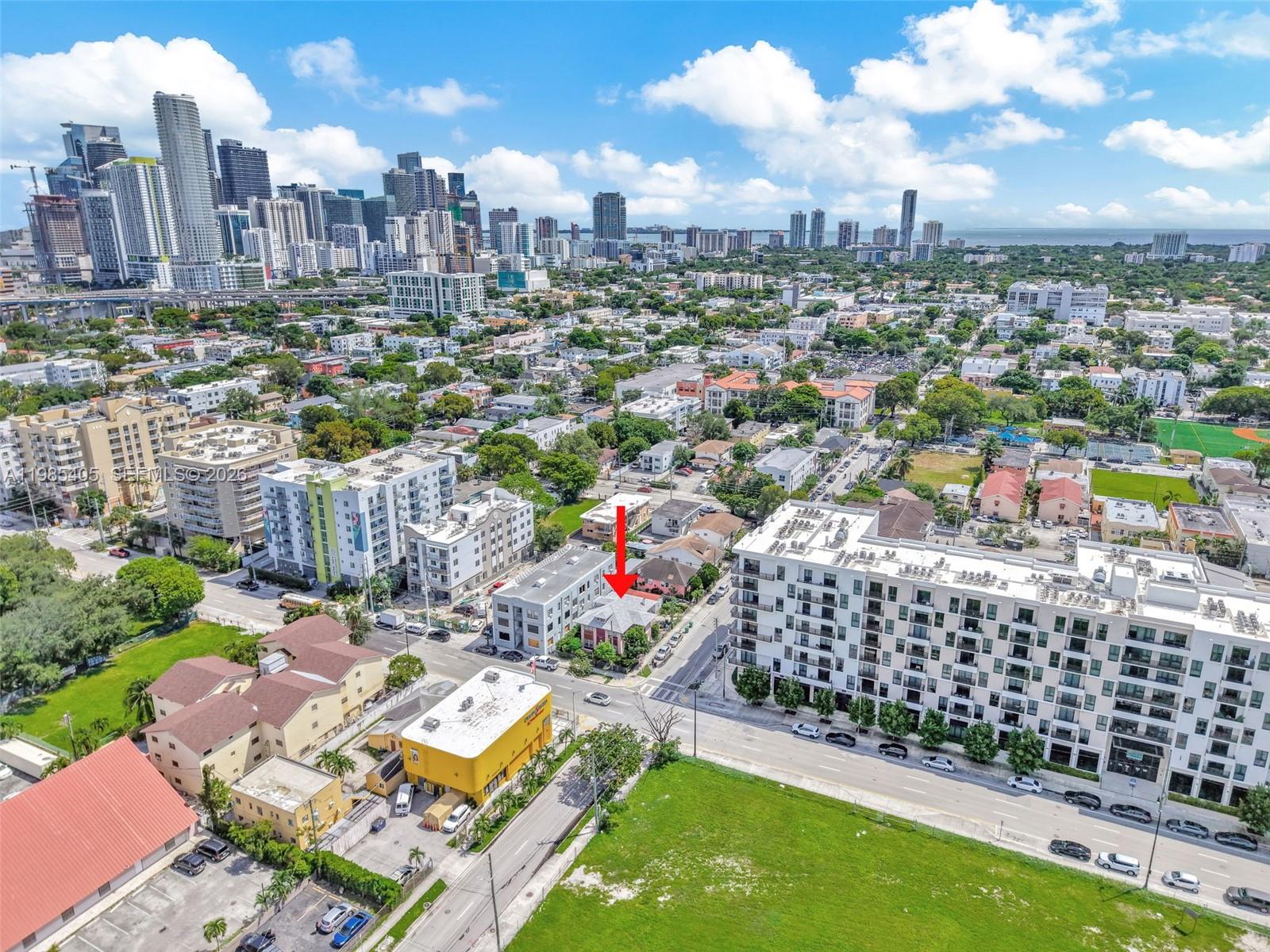 An aerial view shows a small house marked by a red arrow amidst urban buildings — 676 & 119 SW 1st St, Miami FL 33130, MIAMI, FL