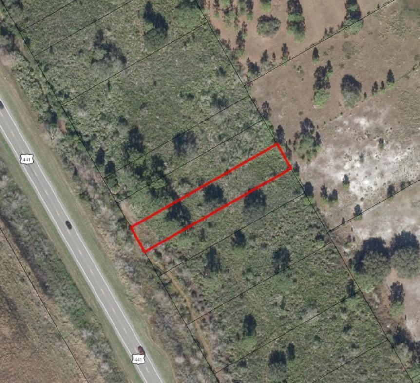 An aerial view shows a rectangular plot of land outlined in red beside a highway — 0 N Hwy 441, Okeechobee FL 34972, OKEECHOBEE, FL