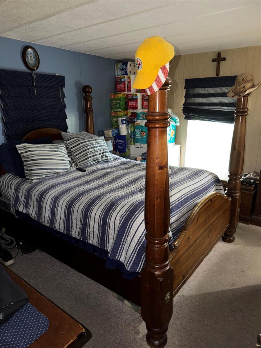 A bedroom features a wooden four-poster bed, blue striped bedding, and a stack of paper products — 5230 SW 29th Terrace, Dania Beach FL 33312, DANIA BEACH, FL