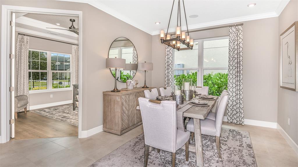 A dining room features a wooden table, upholstered chairs, a sideboard, and a chandelier — 8220 SUMMER NIGHT ROAD, SARASOTA, FL